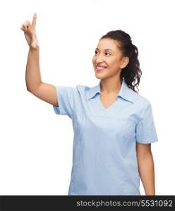 healthcare, medicine and technology concept - smiling african american doctor or nurse pointing to something or pressing imaginary button