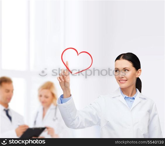 healthcare, medicine and technology concept - smiling female doctor pointing to heart