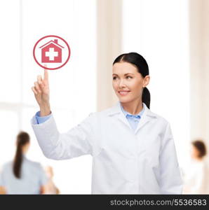 healthcare, medicine and technology concept - smiling female doctor pointing to hospital sign