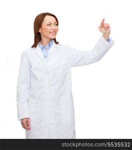 healthcare, medicine and technology concept - smiling female doctor pointing to something or pressing imaginary button