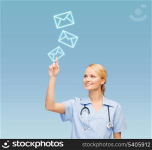 healthcare, medicine and technology concept - smiling young doctor or nurse pointing to envelope