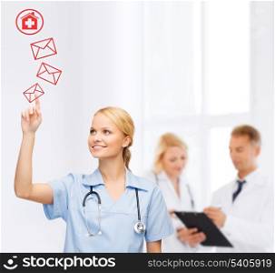 healthcare, medicine and technology concept - smiling young doctor or nurse pointing to red envelope