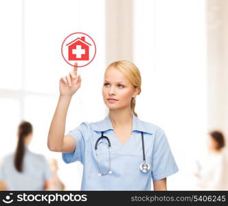 healthcare, medicine and technology concept - smiling young doctor or nurse pointing to red hospital icon