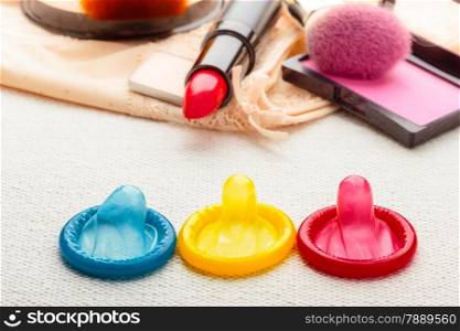 Healthcare medicine, contraception and birth control. Closeup colorful condoms and cosmetics on lace lingerie.