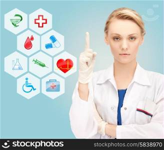 healthcare, medicine, people, warning gesture and symbols concept - young female doctor or nurse pointing her finger up over medical icons and blue background