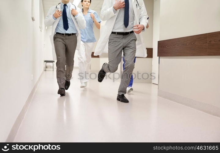 healthcare, people and medicine concept - close up of medics or doctors running along hospital corridor