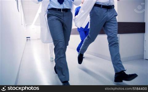 healthcare, people and medicine concept - close up of medics or doctors running along hospital corridor. close up of medics or doctors running at hospital