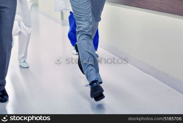 healthcare, people and medicine concept - close up of medics or doctors running along hospital corridor. close up of medics or doctors running at hospital