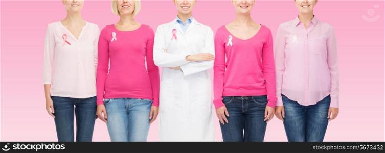 healthcare, people and medicine concept - close up of smiling women in blank shirts with breast cancer awareness ribbons over pink background