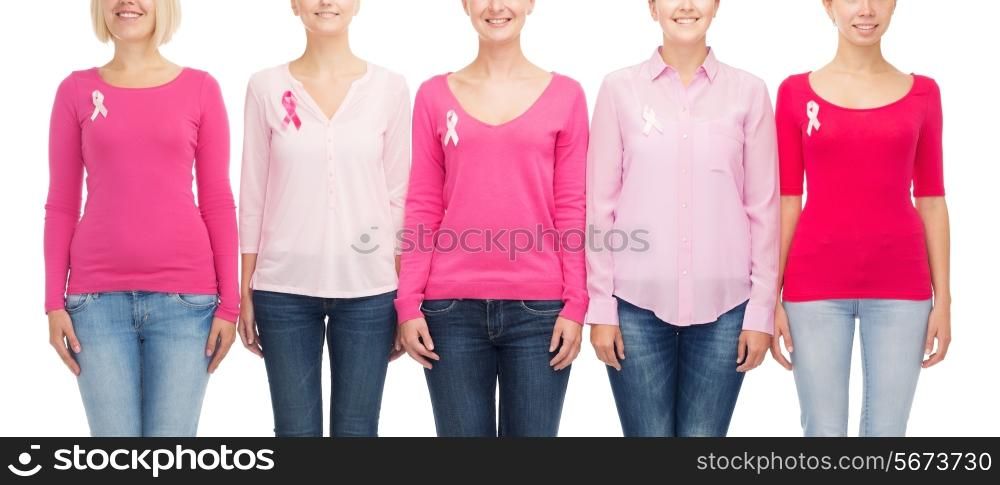 healthcare, people and medicine concept - close up of smiling women in blank shirts with pink breast cancer awareness ribbons over white background