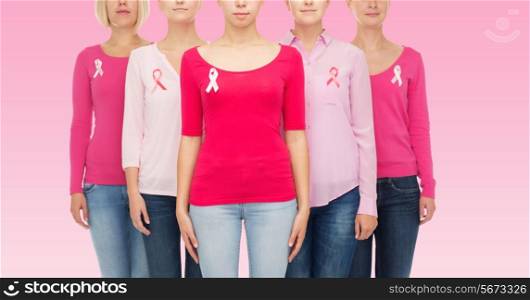healthcare, people and medicine concept - close up of women in blank shirts with breast cancer awareness ribbons over pink background