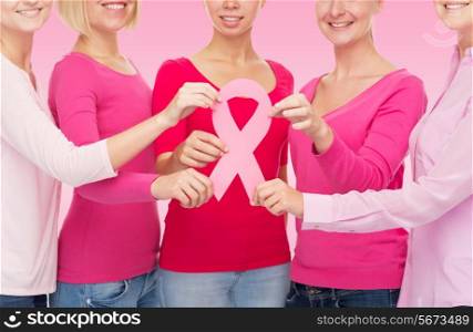 healthcare, people and medicine concept - close up of women in blank shirts with breast cancer awareness ribbon over pink background
