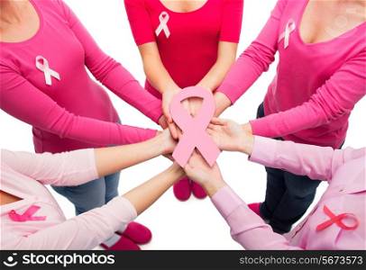 healthcare, people and medicine concept - close up of women in blank shirts with pink breast cancer awareness ribbons over white background