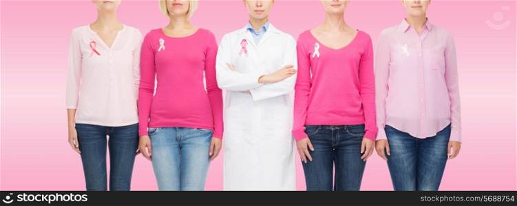 healthcare, people and medicine concept - close up of women in blank shirts with pink breast cancer awareness ribbons over pink background