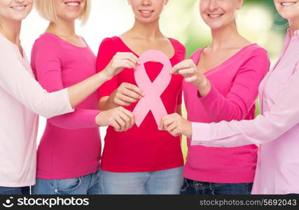 healthcare, people and medicine concept - close up of women in blank shirts with pink breast cancer awareness ribbon over green background