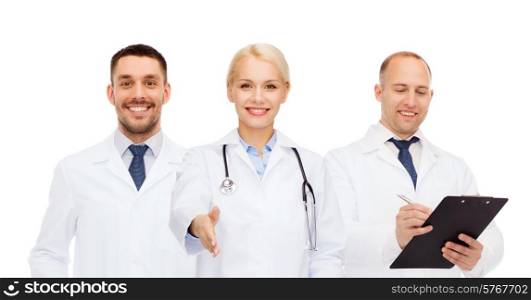 healthcare, people and medicine concept - group of doctors with stethoscope and clipboard making handshake gesture