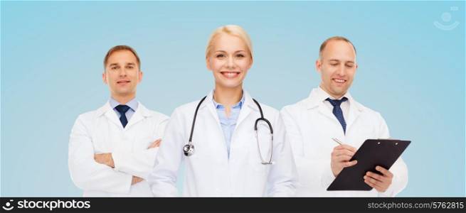 healthcare, people and medicine concept - group of doctors with stethoscope and clipboard over blue background