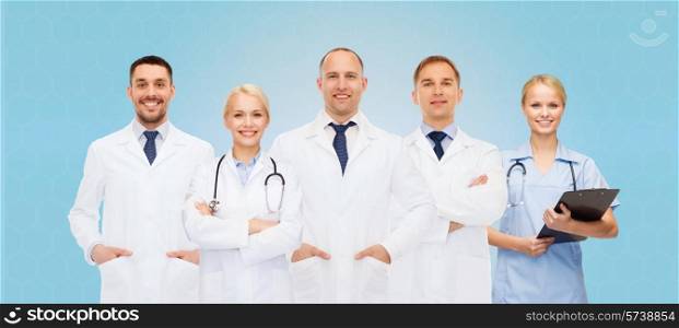 healthcare, people and medicine concept - group of doctors with stethoscopes and clipboard over blue background