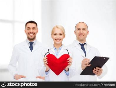 healthcare, people and medicine concept - group of smiling doctors with heart and clipboard over clinic background