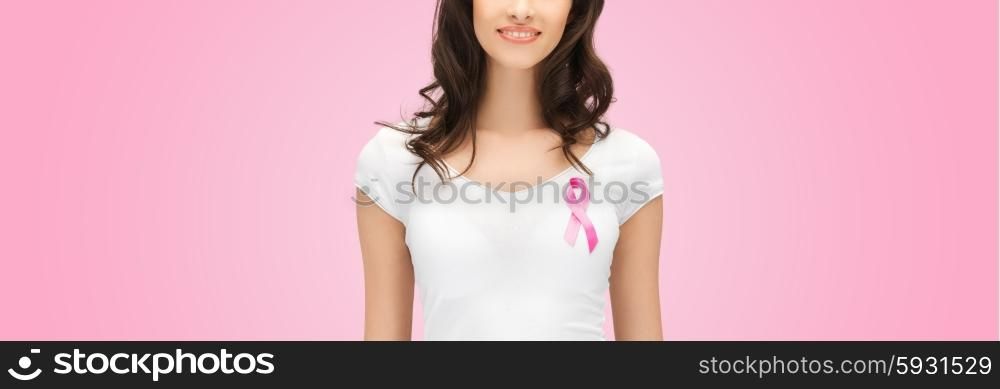 healthcare, people, charity and medicine concept - smiling young woman in t-shirt with breast cancer awareness ribbon over pink background