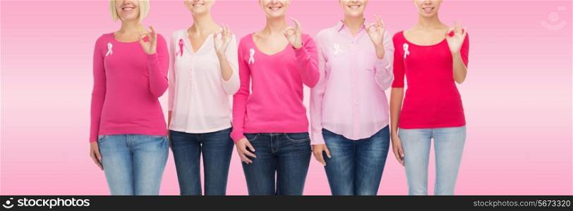 healthcare, people, gesture and medicine concept - close up of smiling women in blank shirts with breast cancer awareness ribbons showing ok sign over pink background