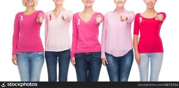 healthcare, people, gesture and medicine concept - close up of smiling women in blank shirts with pink breast cancer awareness ribbons pointing on you over white background