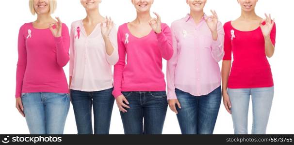 healthcare, people, gesture and medicine concept - close up of smiling women in blank shirts with pink breast cancer awareness ribbons showing ok sign over white background