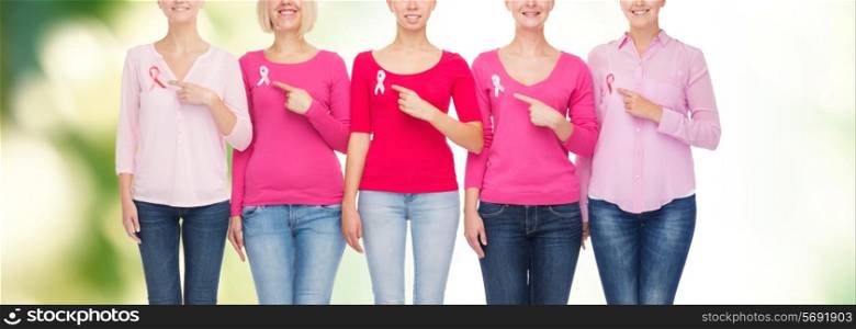 healthcare, people, gesture and medicine concept - close up of smiling women in shirts with pink breast cancer awareness ribbons showing ok sign over green background
