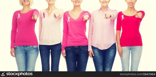 healthcare, people, gesture and medicine concept - close up of smiling women in blank shirts with pink breast cancer awareness ribbons pointing on you over white background