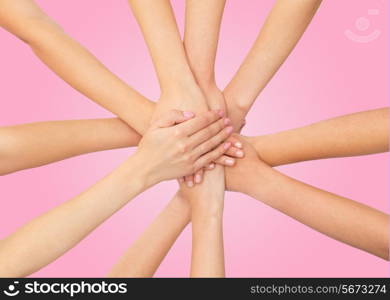 healthcare, people, gesture and medicine concept - close up of women hands on top of each other over pink background