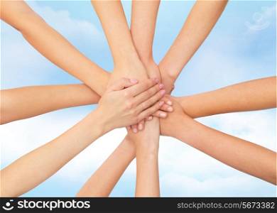 healthcare, people, gesture and medicine concept - close up of women hands on top of each other over blue sky background