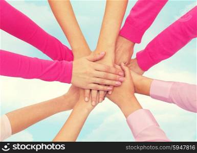 healthcare, people, gesture and medicine concept - close up of women hands on top of each other over blue sky background