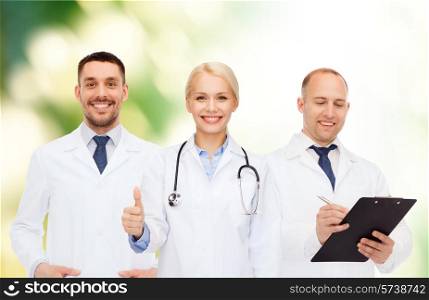 healthcare, people, gesture and medicine concept - group of doctors with stethoscope and clipboard showing thumbs up over green background