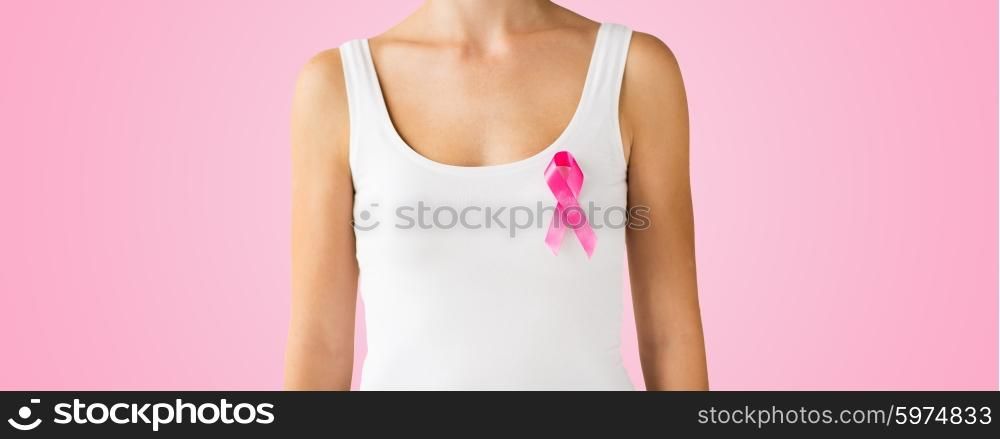 healthcare, people, oncology and medicine concept - close up of woman in white shirt with pink cancer awareness ribbon