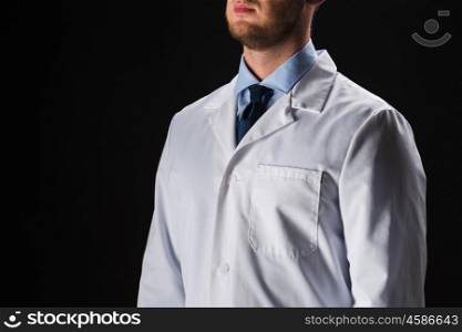 healthcare, people, profession and medicine concept - close up of male doctor in white coat over black background