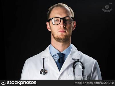 healthcare, people, profession and medicine concept - close up of male doctor in white coat with stethoscope over black background