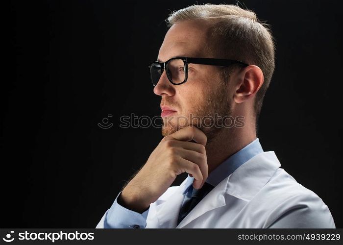 healthcare, people, profession and medicine concept - close up of male doctor in white coat over black background. close up of male doctor in white coat