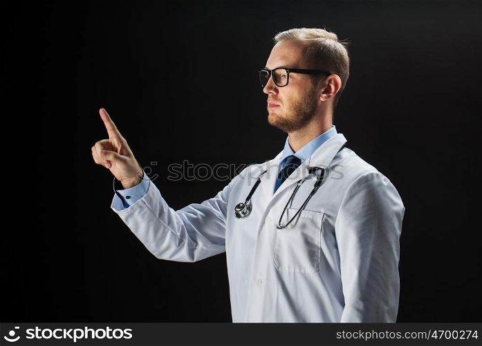 healthcare, people, profession and medicine concept - male doctor in white coat with stethoscope touching something imaginary over black background