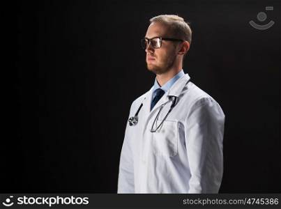 healthcare, people, profession and medicine concept - male doctor in white coat with stethoscope over black background