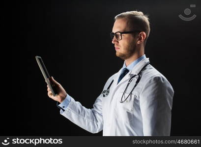 healthcare, people, technology and medicine concept - male doctor in white coat with stethoscope and tablet pc computer over black background