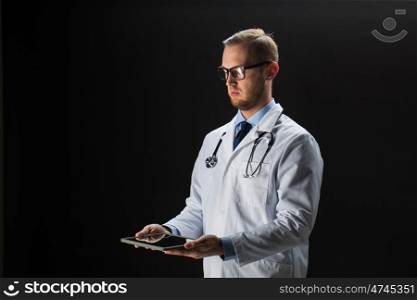 healthcare, people, technology and medicine concept - male doctor in white coat with stethoscope and tablet pc computer over black background