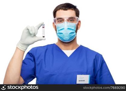 healthcare, profession and medicine concept - doctor or male nurse in blue uniform, face mask for protection from virus disease, goggles and gloves with blood in test tube over white background. male doctor in mask with blood in test tube