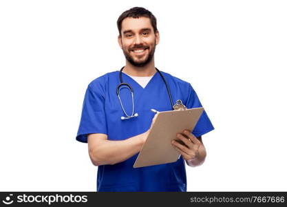 healthcare, profession and medicine concept - happy smiling doctor or male nurse in blue uniform writing medical report on clipboard over white background. male doctor writing medical report on clipboard