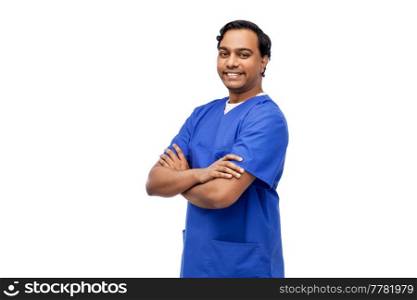 healthcare, profession and medicine concept - happy smiling indian doctor or male nurse in blue uniform with crossed arms over white background. happy indian doctor or male nurse in blue uniform