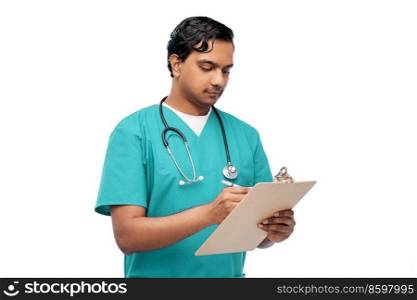 healthcare, profession and medicine concept - indian doctor or male nurse in blue uniform writing medical report on clipboard over white background. male doctor writing medical report on clipboard