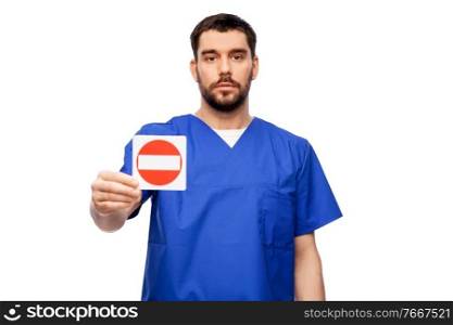 healthcare, profession and medicine concept - male doctor in blue uniform showing stop sign over white background. doctor or male nurse showing stop sign