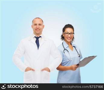 healthcare, profession and medicine concept - smiling doctors with clipboard and stethoscopes over blue background