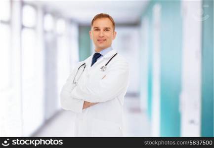healthcare, profession and medicine concept - smiling male doctor in white coat with stethoscope over hospital background