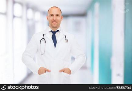healthcare, profession and medicine concept -smiling male doctor in white coat with stethoscope over hospital background