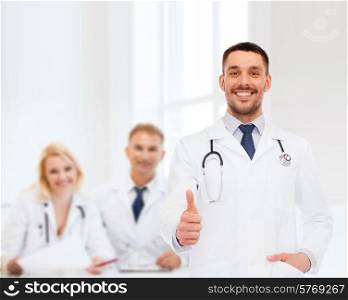 healthcare, profession and medicine concept - smiling male doctor with stethoscope showing thumbs up over white background